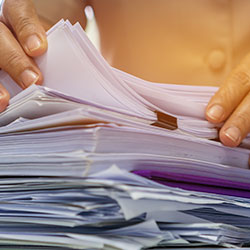 Hands prepping documents for scanning